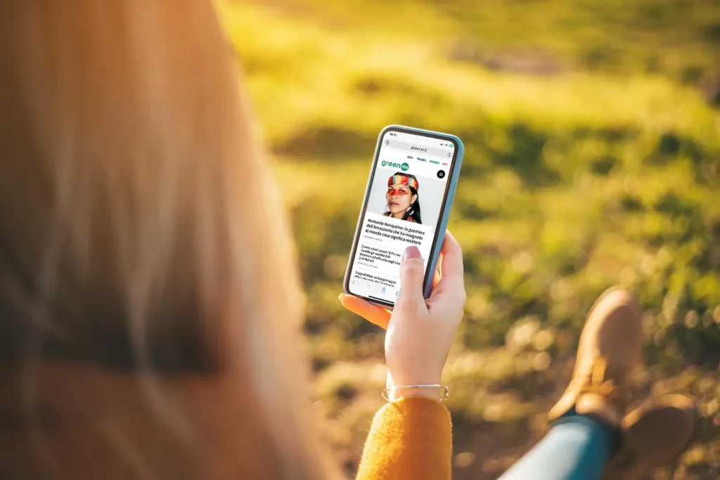 Ragazza che legge GreenMe sul suo smartphone